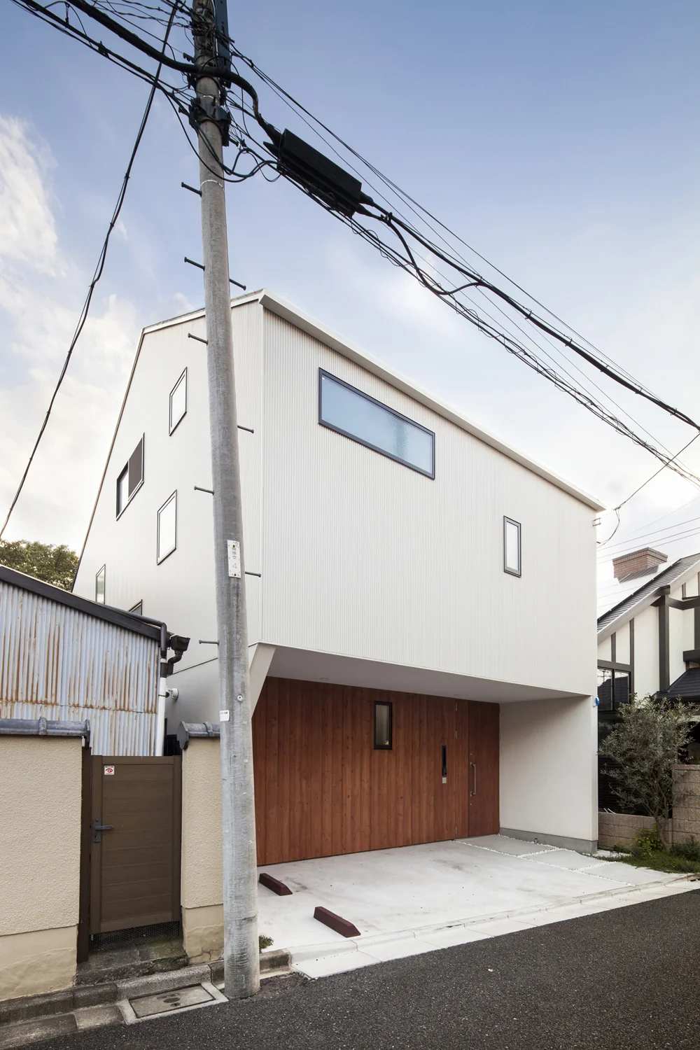 The second floor cantilevers like an eave, creating a parking space underneath and opening up terrace and garden areas on the south side.