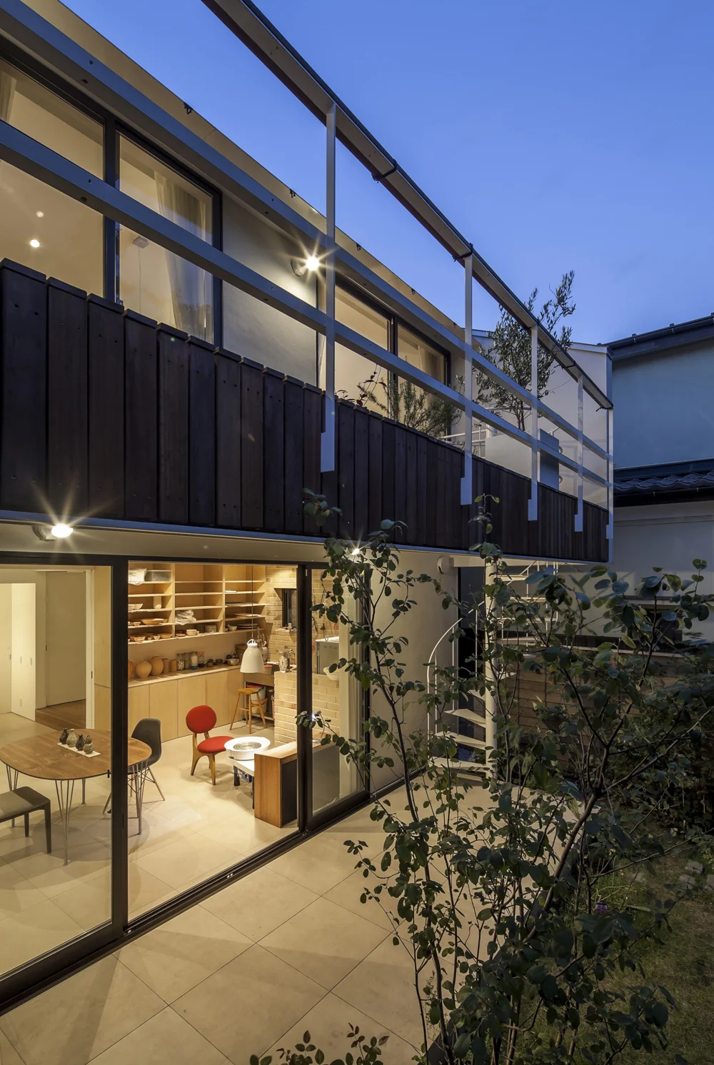The first-floor terrace and second-floor deck terrace are connected by a spiral staircase, seamlessly linking the atelier and living spaces.