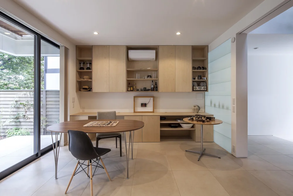 Built-in furniture within the atelier is crafted from Russian birch with a clear lacquer finish, combining display shelves and cupboards.