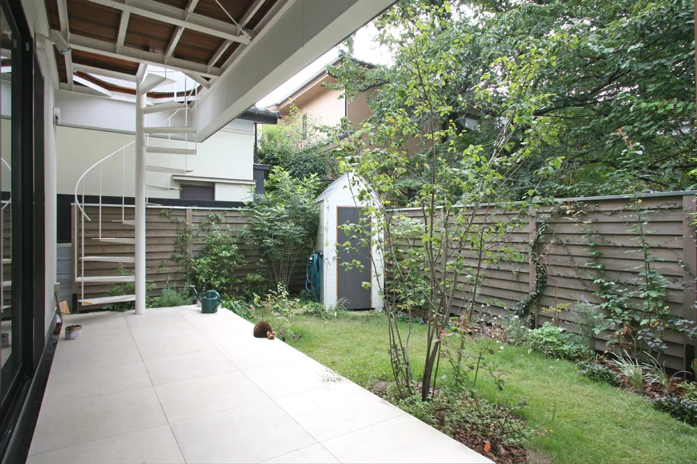 The southern garden, enclosed by wooden fencing, is dedicated to gardening; the white shed serves as storage for gardening tools.