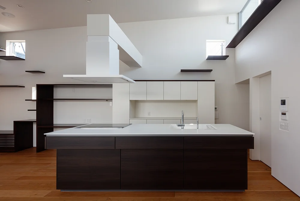 The island kitchen, designed for shared family use, is complemented by custom-built kitchen storage on the back wall.