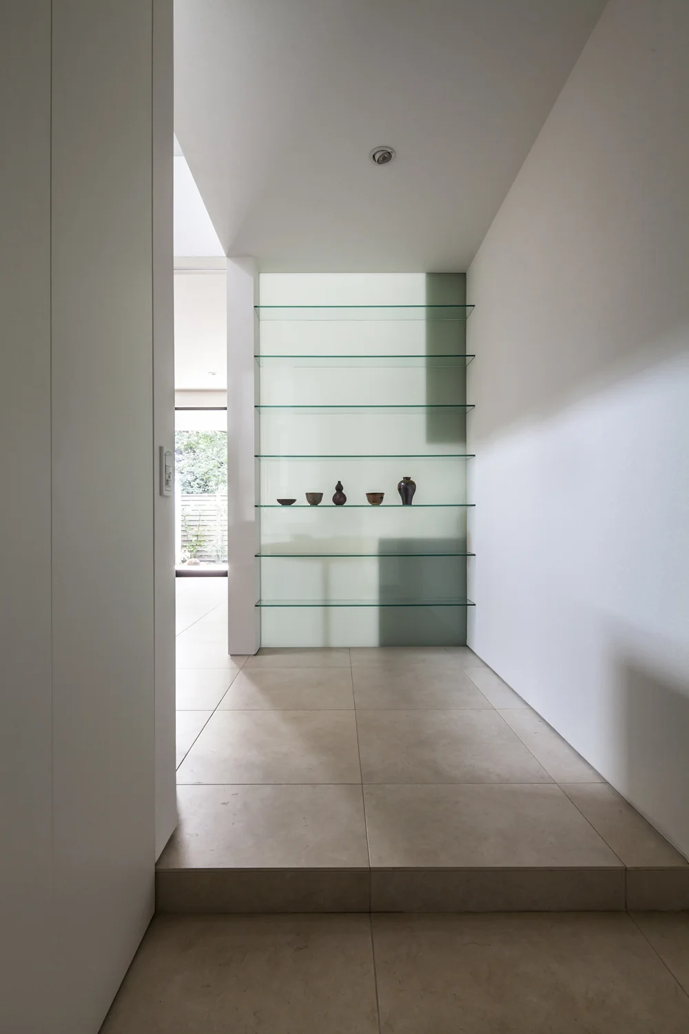 Upon entering the foyer, a glass display shelf illuminated by southern light warmly welcomes visitors.