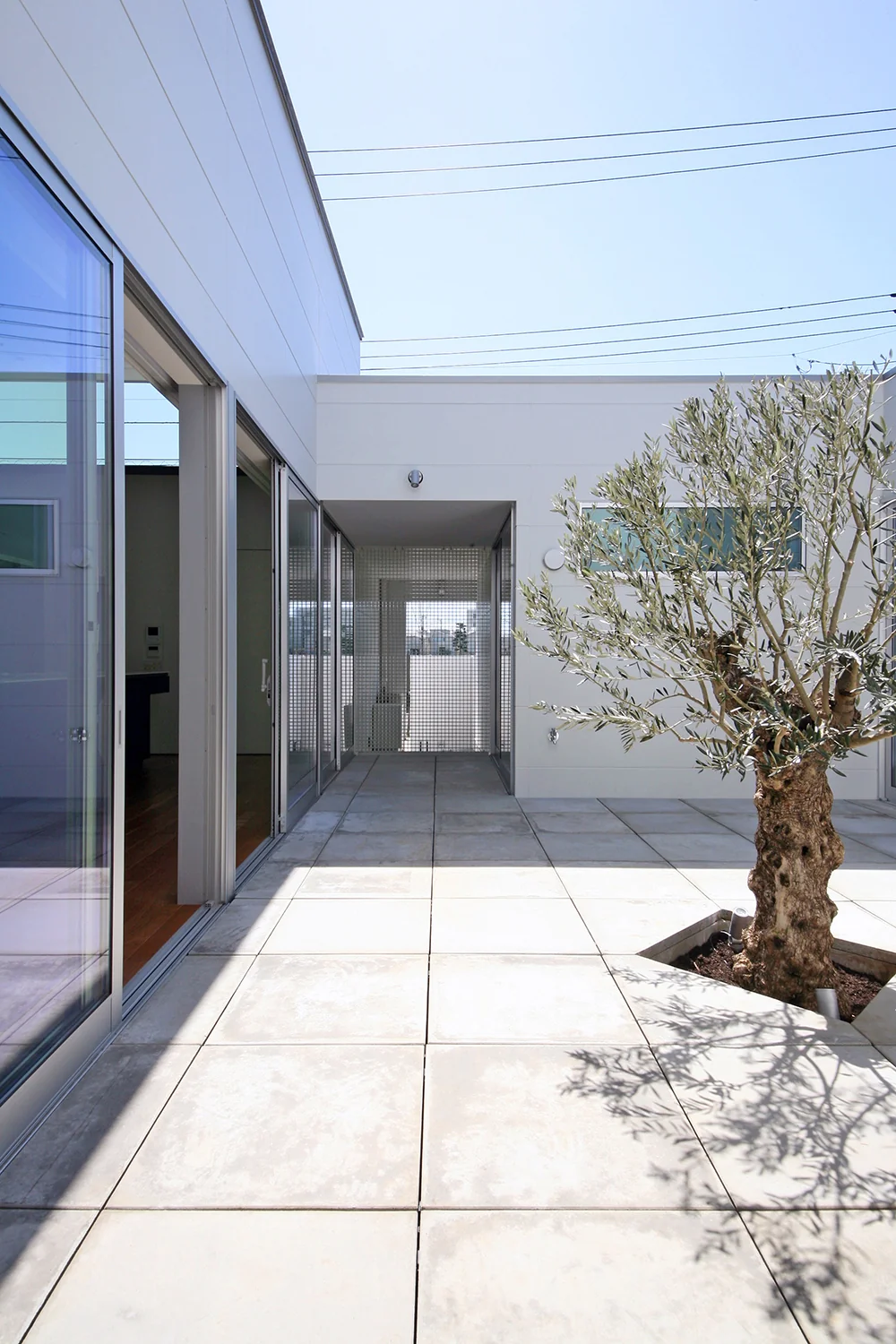 The courtyard opens partially toward the street side with fiber grating installed to prevent cats from escaping.