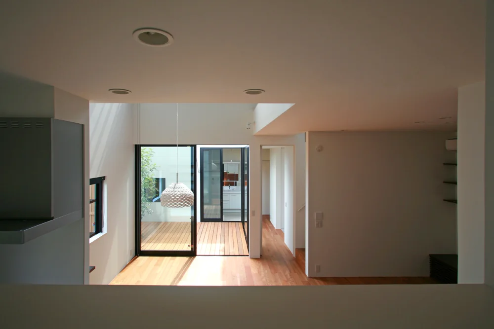 From the hobby room’s opening, there is a clear view passing over the courtyard toward the washroom beyond.