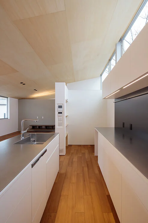 Ample storage is provided with well-appointed cabinetry behind the kitchen, alongside a discreetly positioned refrigerator alcove and pantry.