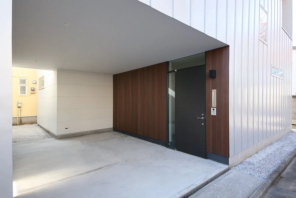 Pilotis-style parking and bicycle storage area seamlessly integrated with the entrance porch.