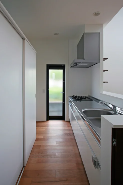 Custom cabinetry behind the kitchen houses appliances, and a door is installed at the entrance to restrict cat access.