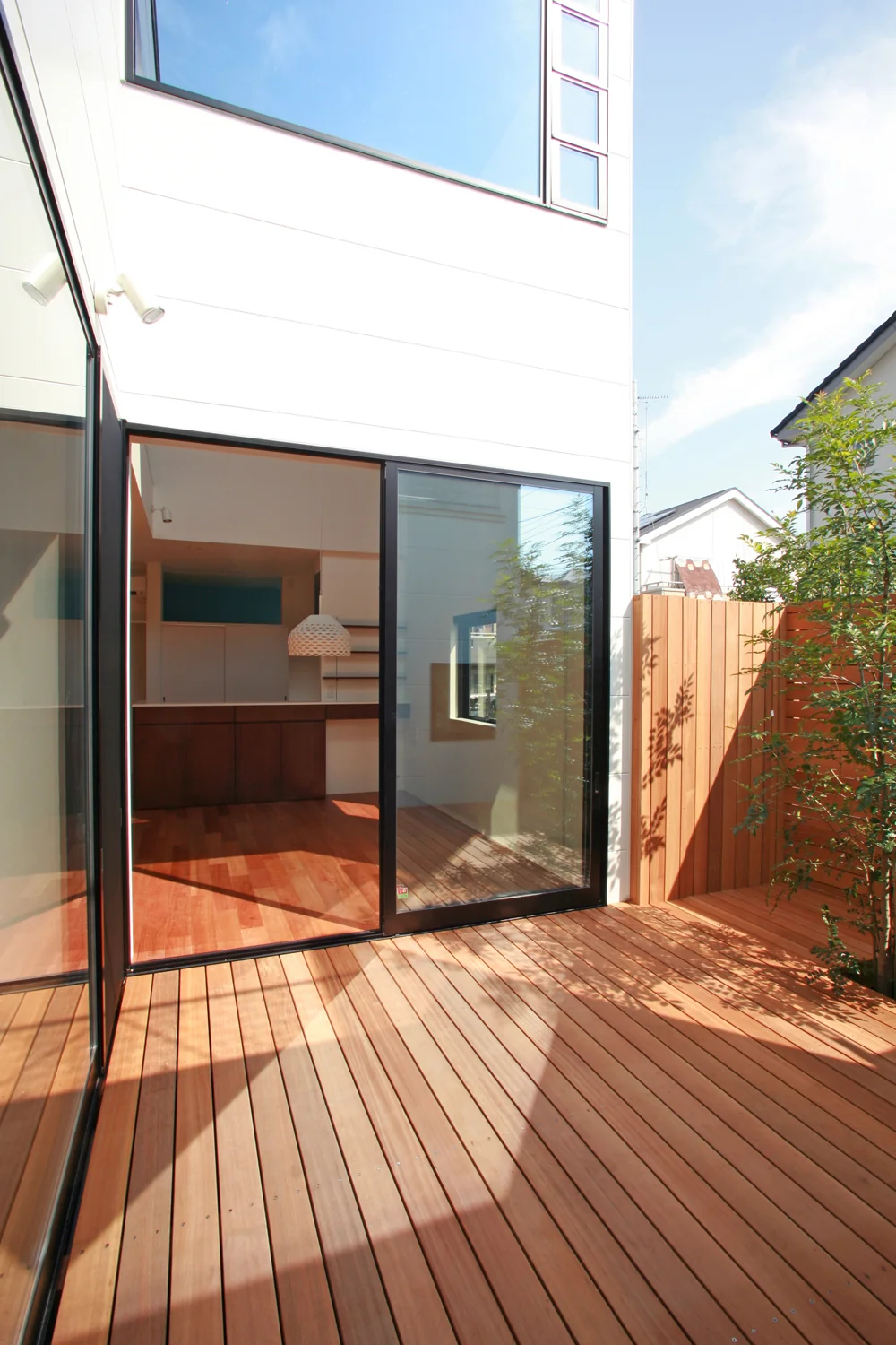 The courtyard connects seamlessly with the interior on a level plane, fostering a sense of unity; it is enclosed by wooden fencing designed to prevent cats from escaping.