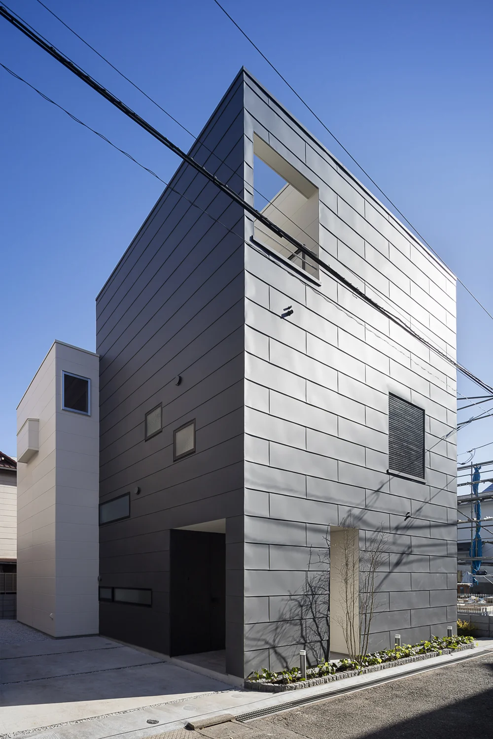 2階建ての白い箱と3階建ての黒い箱を組み合わせた外観｜室内化したテラスを持つ家