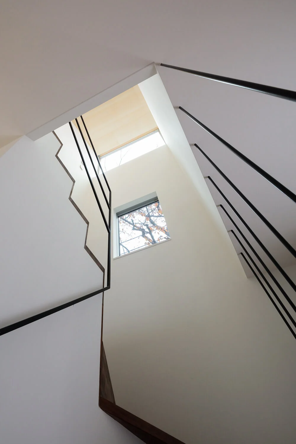 Cherry blossom trees are perfectly framed through windows along the staircase, enlivening the ascent and descent.