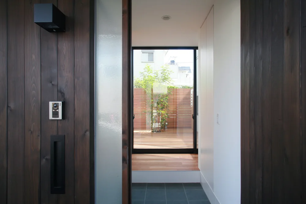 Opening the front door reveals the courtyard directly ahead, with a Shima Tōneriko (Fraxinus griffithii) serving as the symbolic centerpiece.