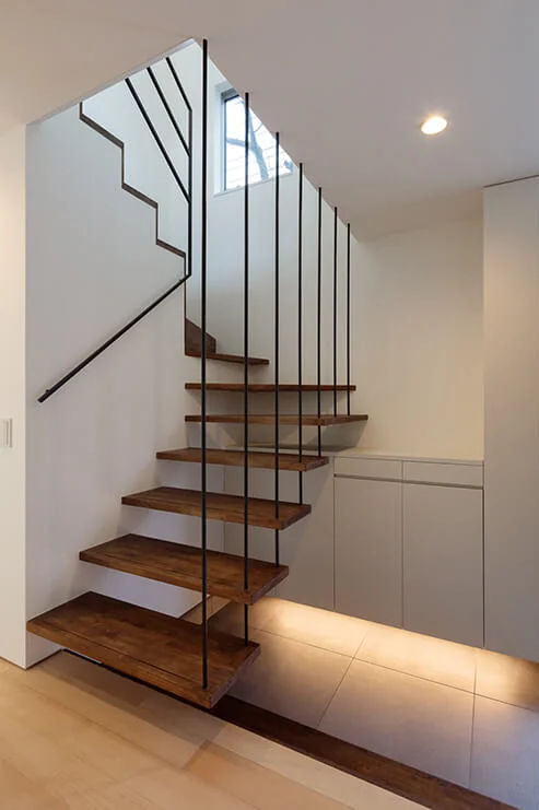 The staircase to the second floor is suspended by tension rods, creating a sense of lightness and spatial expansion.
