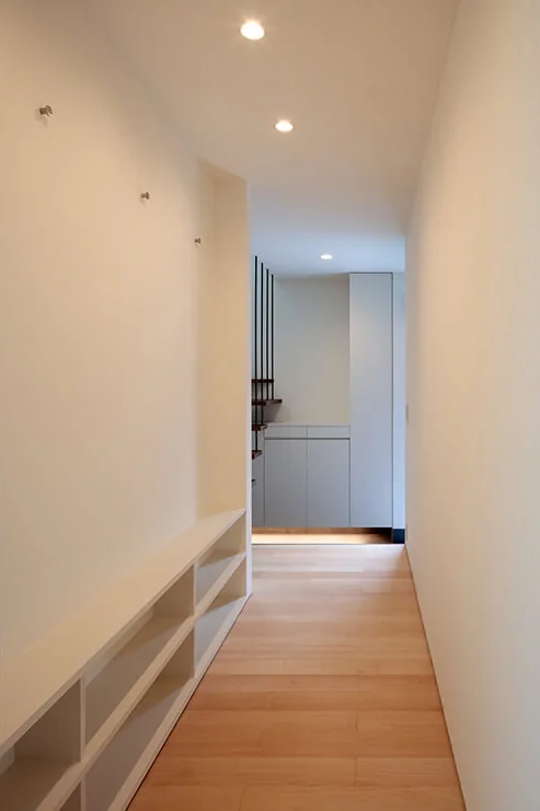 The corridor is slightly widened to accommodate a bookshelf and coat hooks for the entire family.