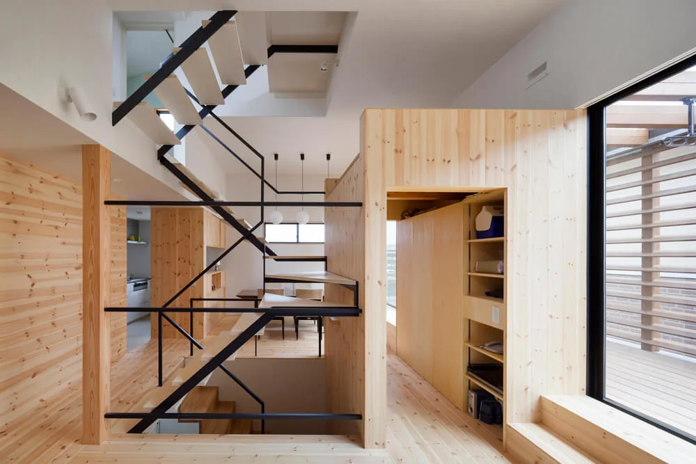 On the second floor, a staircase penetrates between the living and dining areas with a ceiling height of one and a half stories