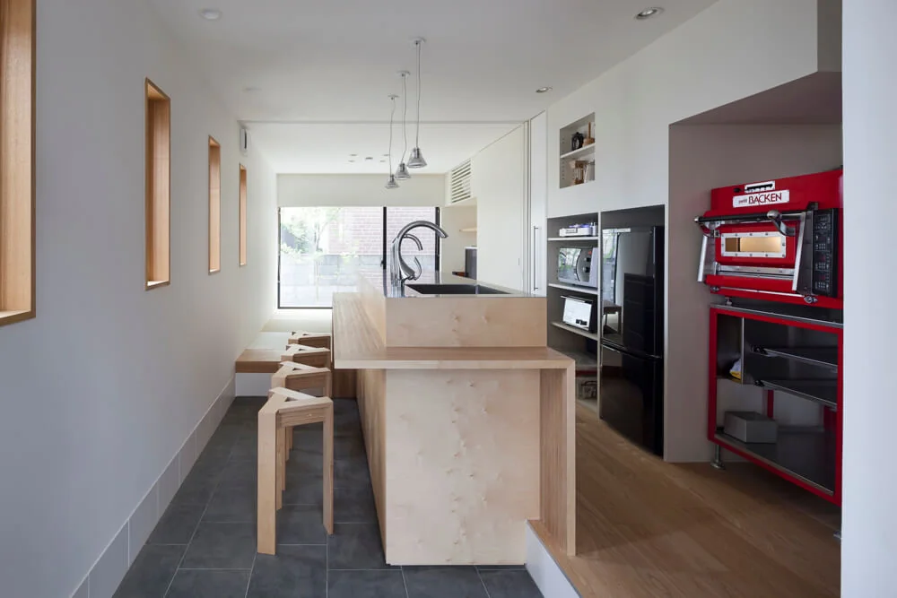 Upon entering the entrance, a spacious earthen floor area features a custom-built kitchen counter for the husband’s confectionery hobby