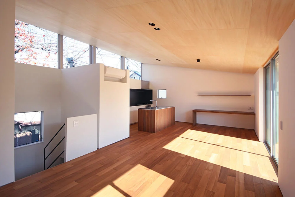 A spacious living-dining-kitchen (LDK) occupies the second floor, with a horizontally elongated clerestory window offering panoramic views of the cherry blossom row.