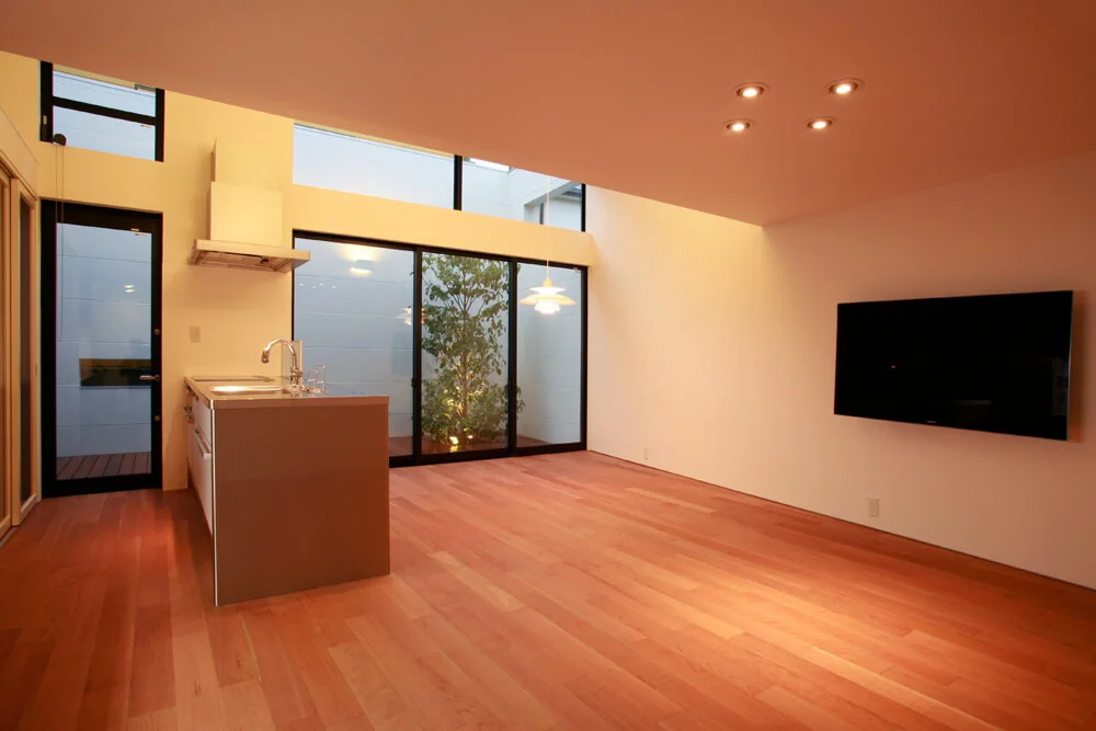 The wall-mounted TV is seamlessly integrated into the wall, with AV equipment neatly stored in furniture on the opposite side.