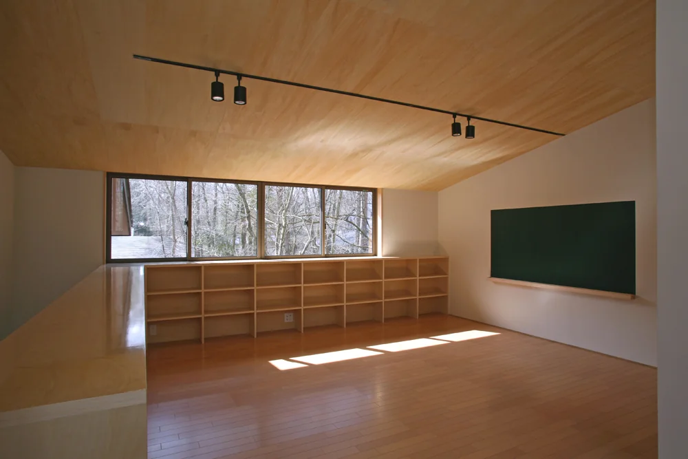 The half-height wall doubles as a bookshelf, with a custom blackboard on the wall for the child’s free drawing