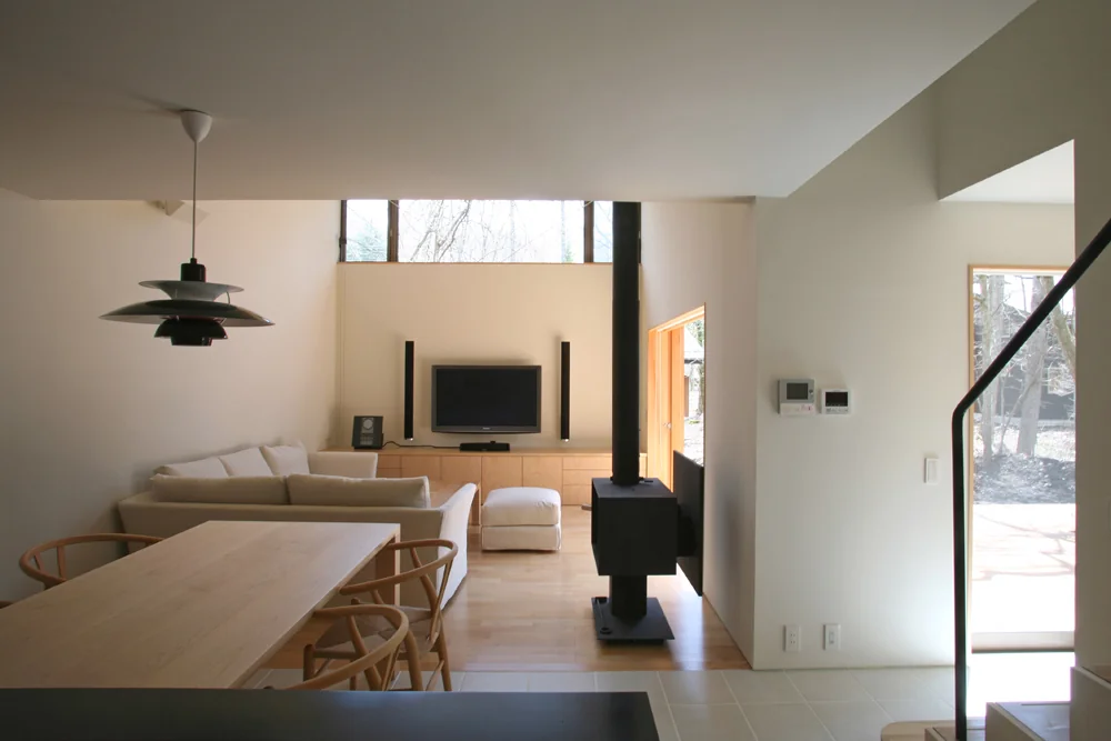 Tiled flooring extends continuously from the entrance through to the dining kitchen｜House Nestled Among the Trees