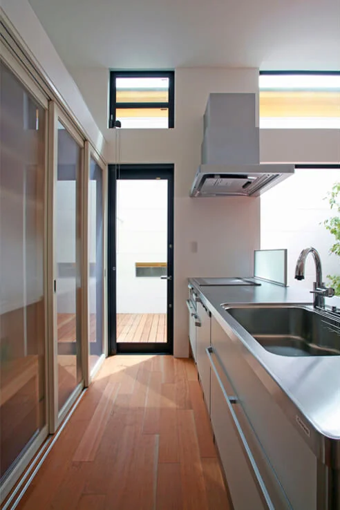 Behind the kitchen is storage for tableware and appliances, featuring semi-transparent sliding doors that can be opened fully to facilitate cooking activities.