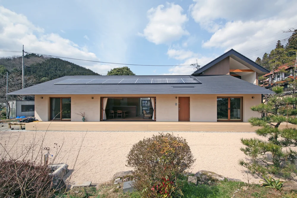 主要室や客用の玄関が庭に面する、屋根には太陽光パネルを載せている