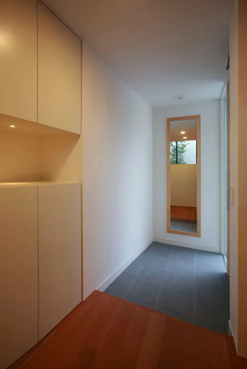 The entrance hall includes a full-length mirror that reflects the symbolic tree, creating a welcoming visual motif.