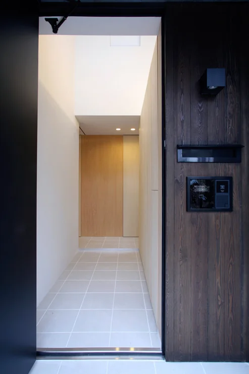 The entrance features a double-height ceiling with tiled flooring and expansive wall storage for shoes and snowboards