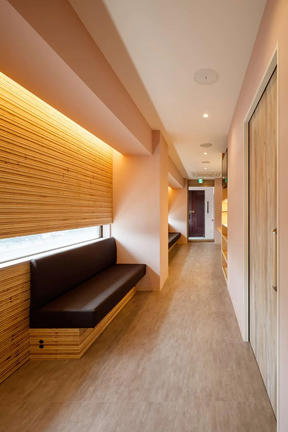 View from Examination Room 2 toward the waiting area entrance; illuminated display shelves for cosmetic products are located mid-right.
