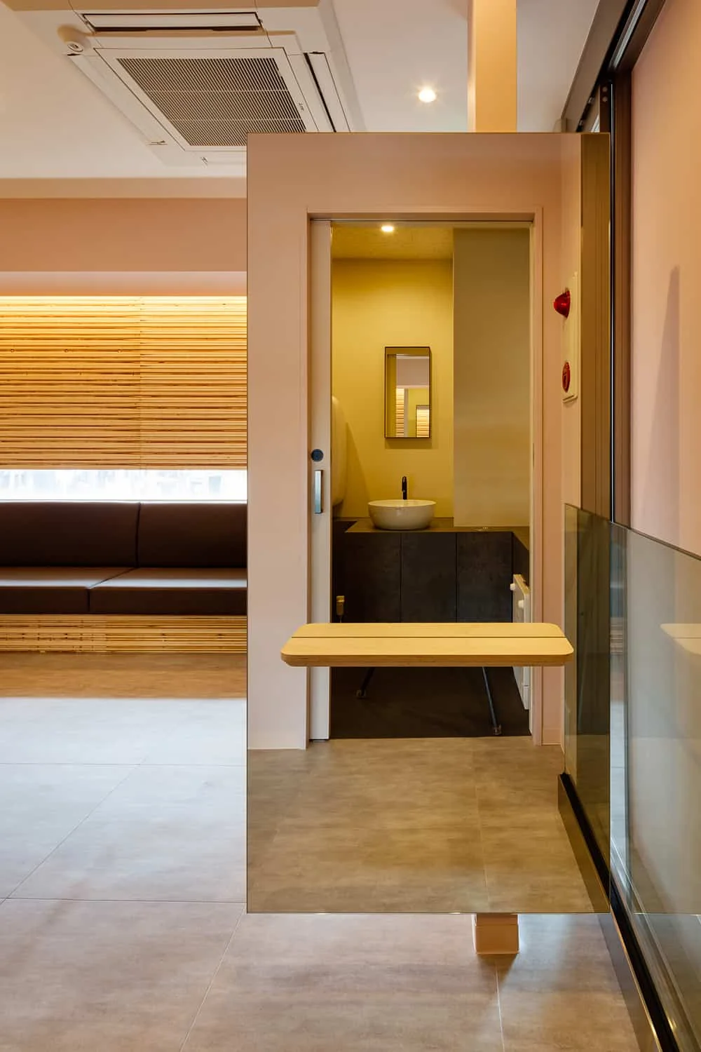 Screen with a full-length mirror positioned opposite the restroom entrance, serving to block sightlines from the waiting area.