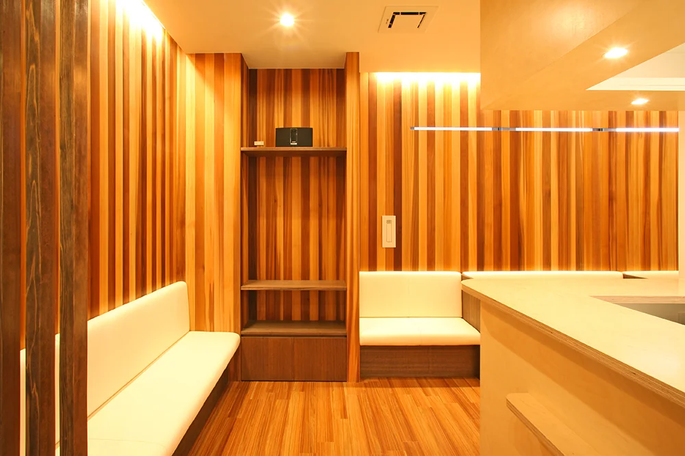 Waiting area with walls clad in solid red cedar panels softly illuminated by indirect lighting
