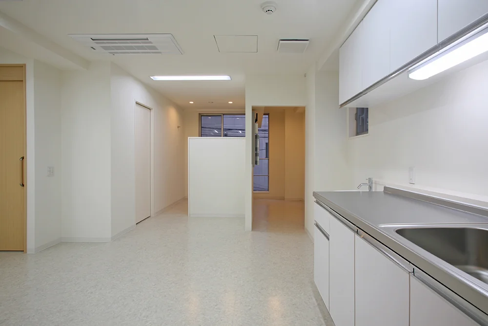 Treatment room with a predominantly white color scheme; sliding door entrance visible on the left
