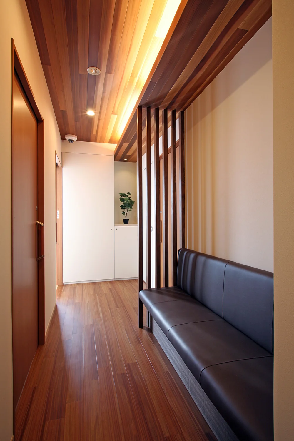 Waiting corner bench in dark brown with a wood-paneled ceiling, creating a distinct atmosphere from the main waiting area