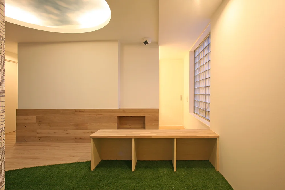 Bench doubling as storage in the kids’ corner in the foreground; guest handwashing area located at the far right