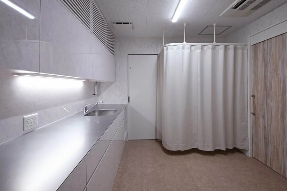 Behind the curtain in Examination Room 1, a pediatric examination table is placed.