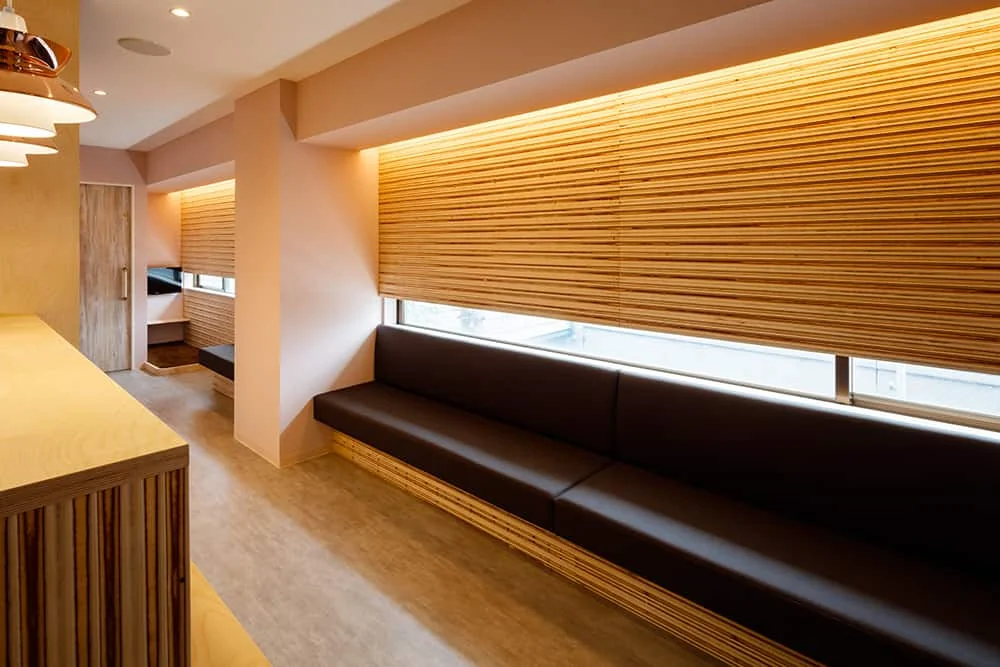 Interior with wooden panels and pink wallpaper; apertures are narrowed and indirect lighting creates a soft ambiance.