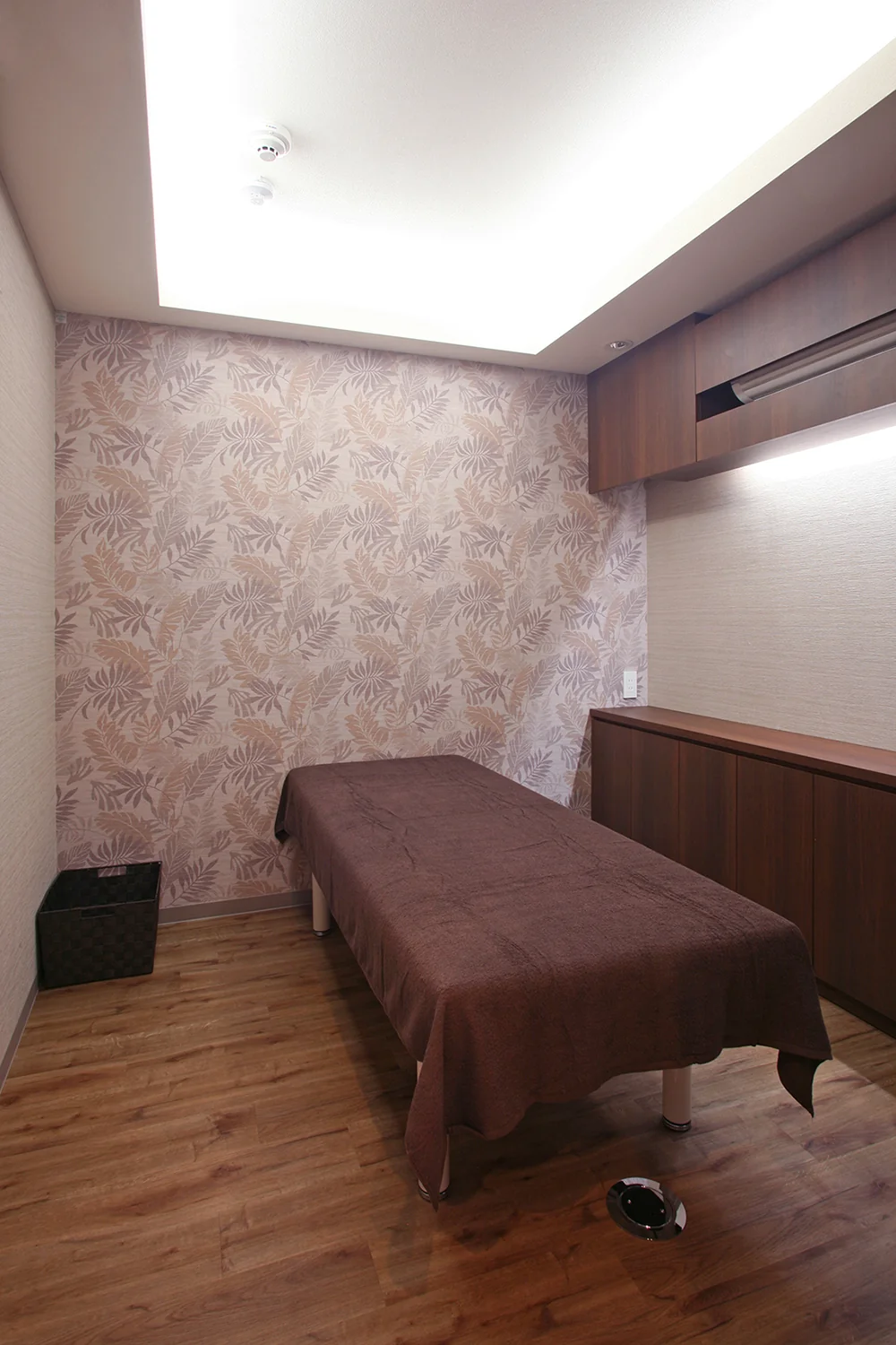 Treatment room with Asian-inspired interior design; plumbing and ventilation concealed within storage furniture