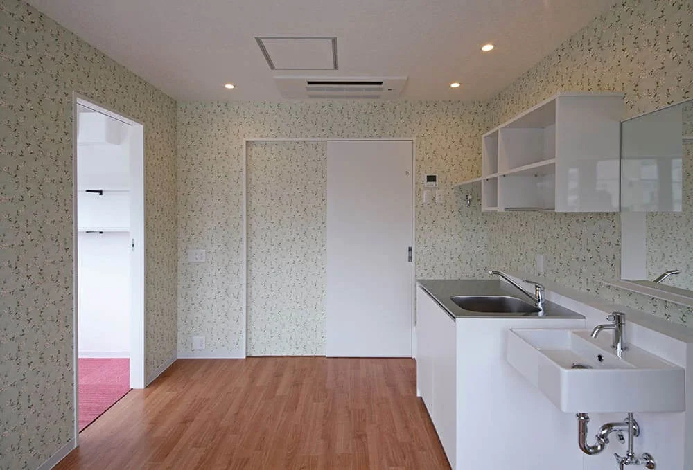 Staff room with the director’s office on the left; sliding door ahead connects to Examination Room 2.