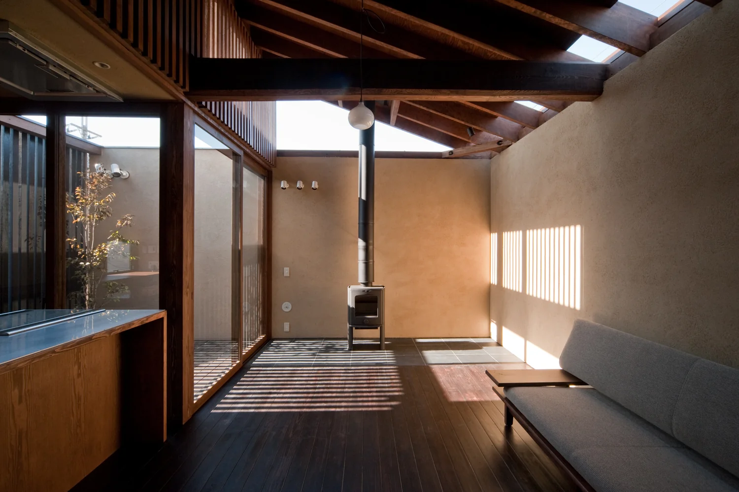 Gentle, continuous natural light filters through high-side windows, skylights, and vertical wooden slats.