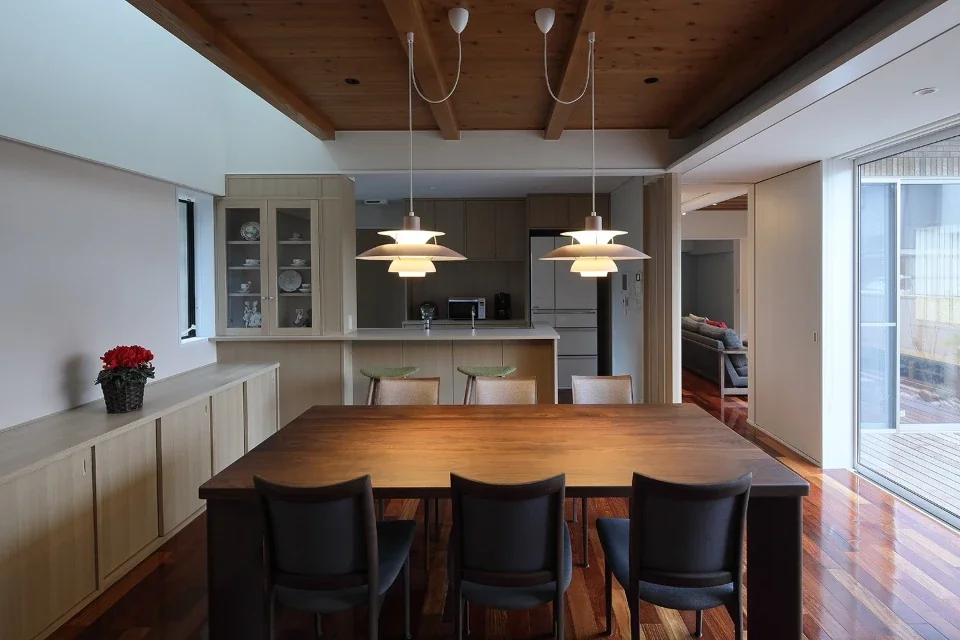 The dining room has a low ceiling on the wooden-deck side, while the opposite side opens up into a void to bring in light from above.