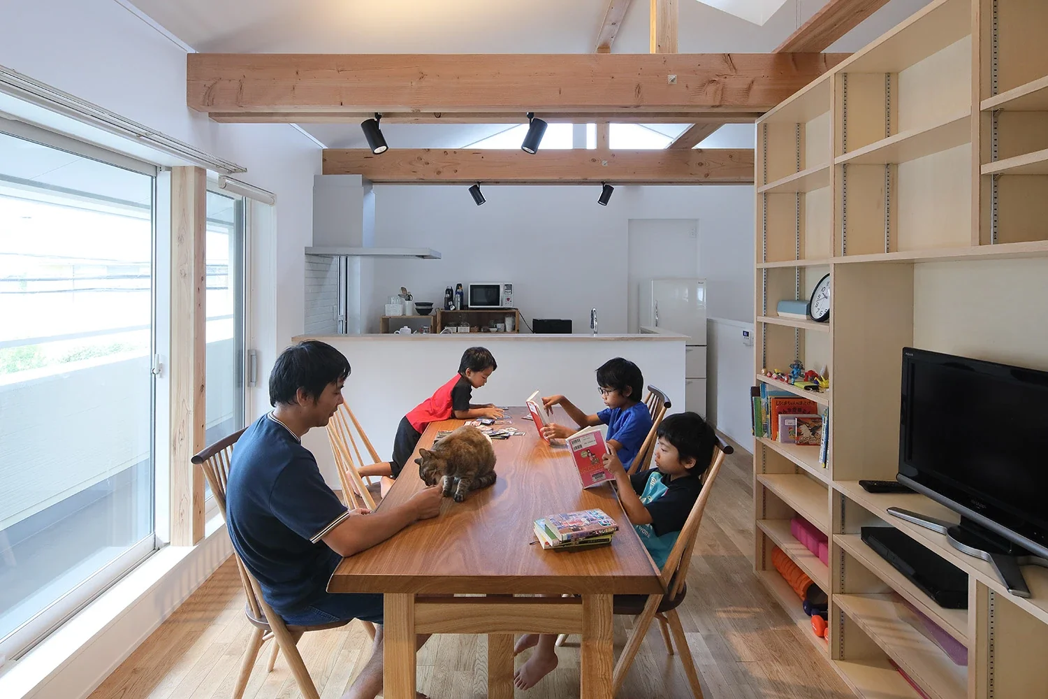 The second-floor living-dining room is filled with natural light and has a generously high ceiling.