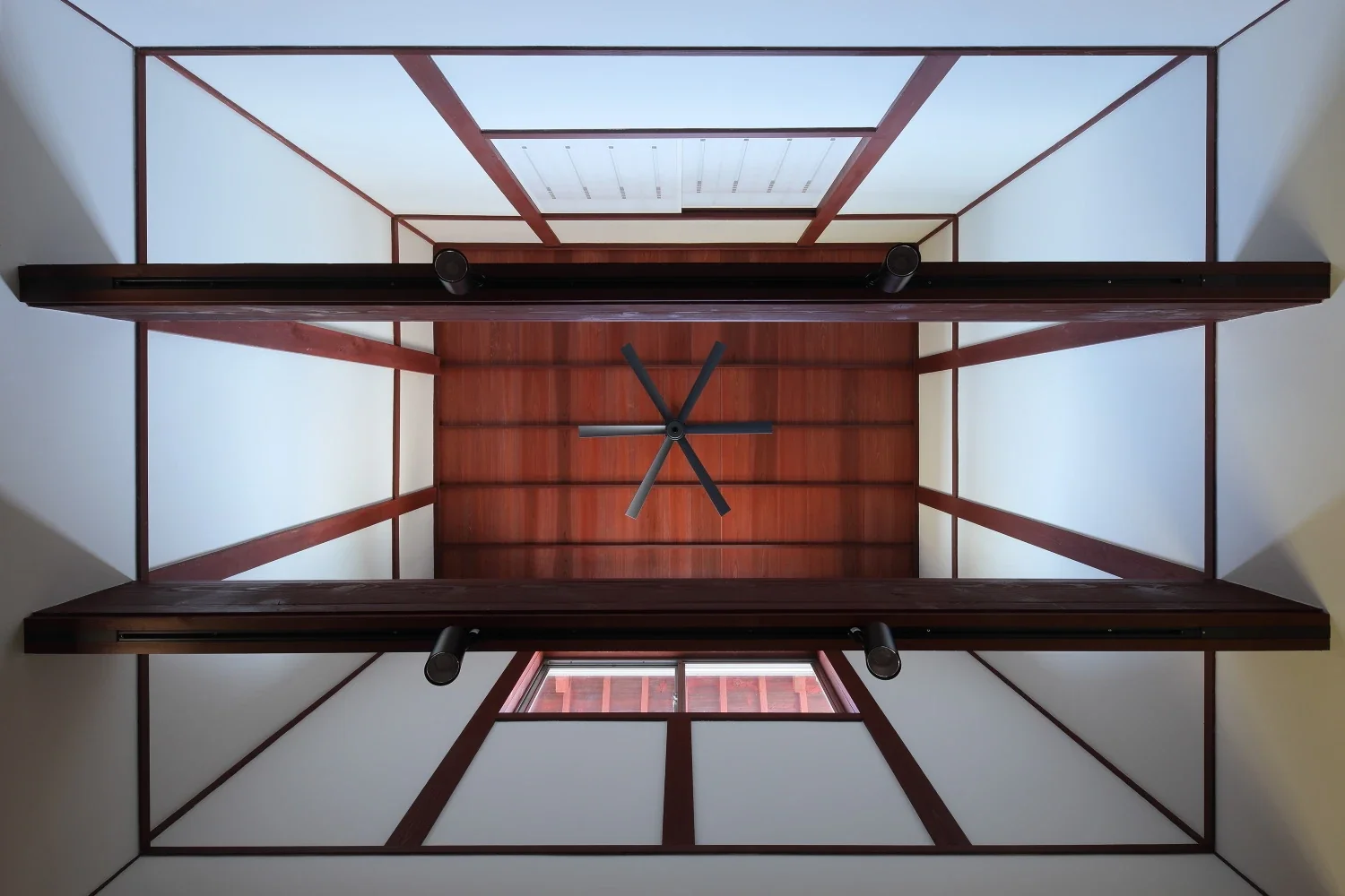 The second-floor slab above the dining room was removed to create a void. The cedar ceiling boards have a lustrous vermilion-red finish.