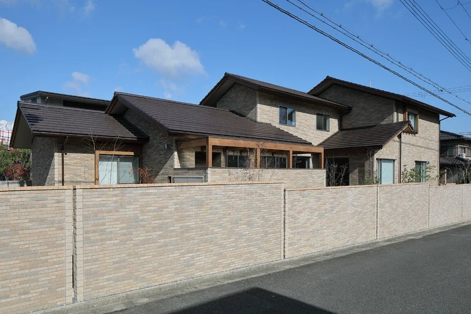 The overlapping roofs create a rhythm, while the wall is integrated with the building.