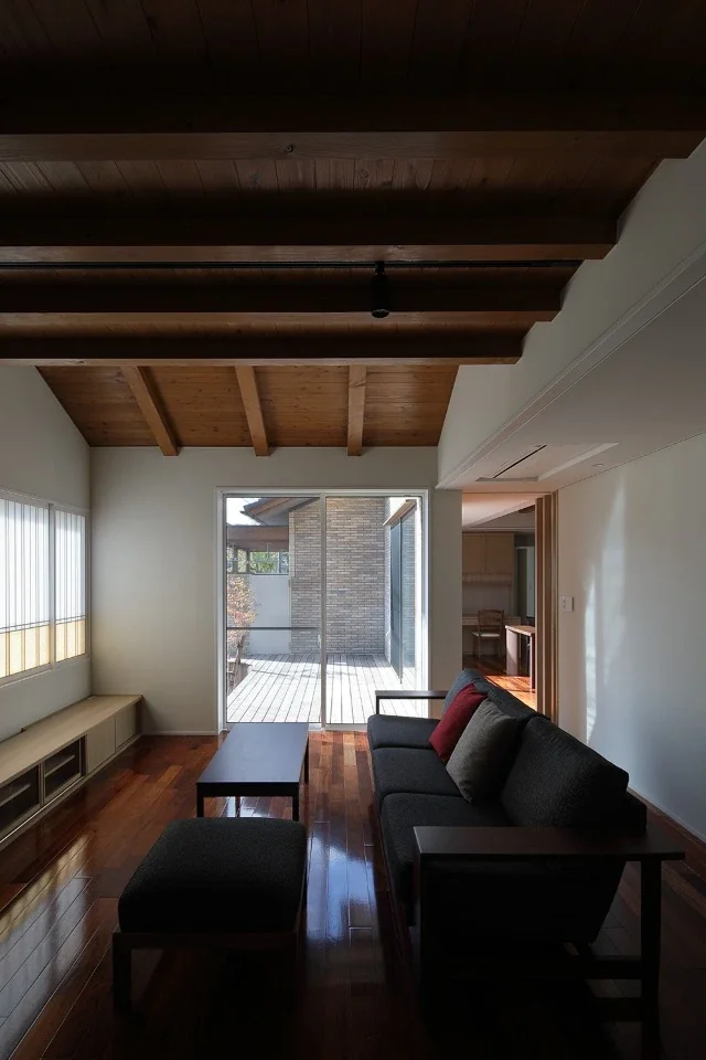 The living and dining rooms form an L-shape around the wooden deck.