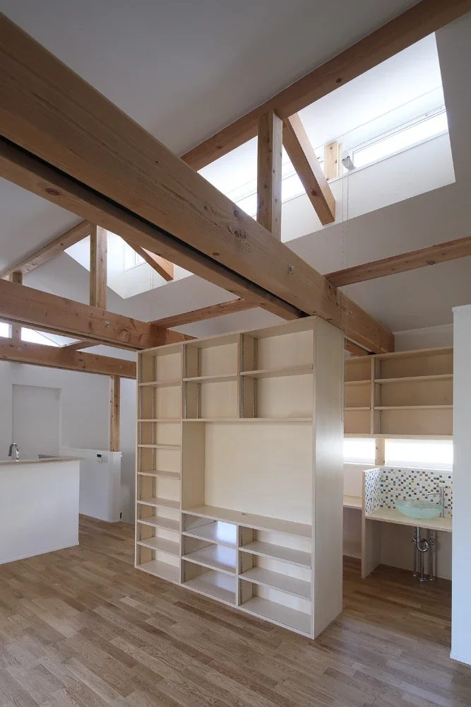 Part of the shelving unit separating the dining room from the desk corner is open, allowing it to be used from both sides.