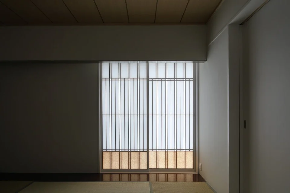 A dropped wall is positioned in front of the paper shoji screens to reduce the sense of height; the floor is painted reddish brown.