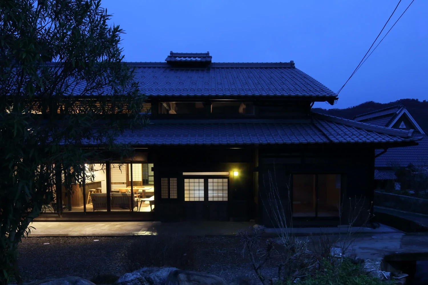 The new entrance and living room emerge in the night.