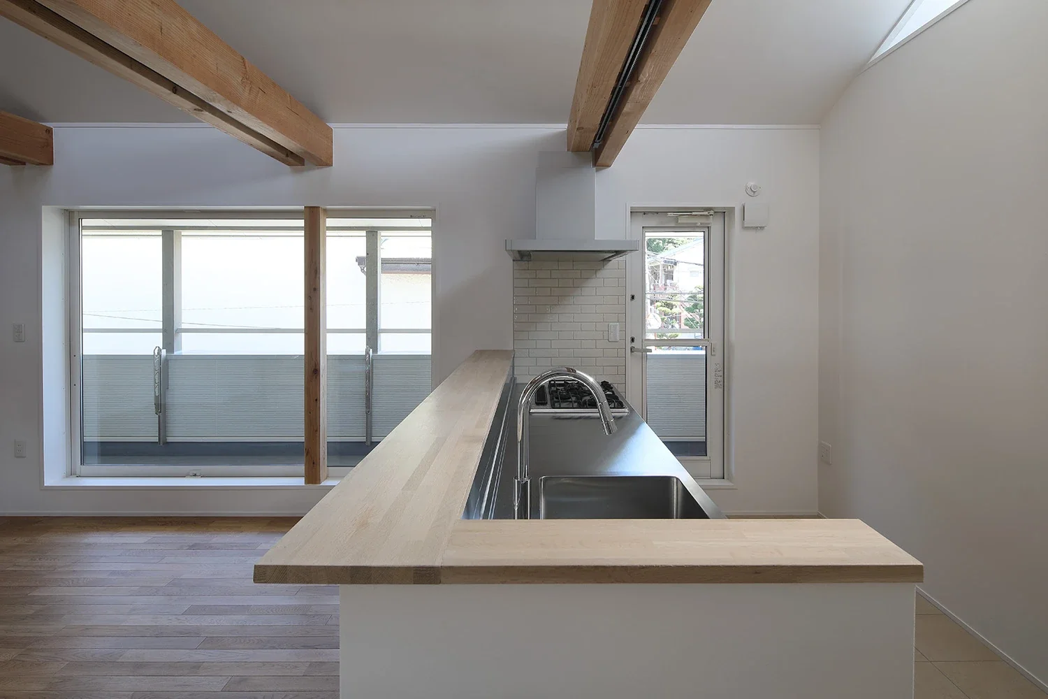 The stainless-steel kitchen, with a counter concealing the work surface, faces the balcony.