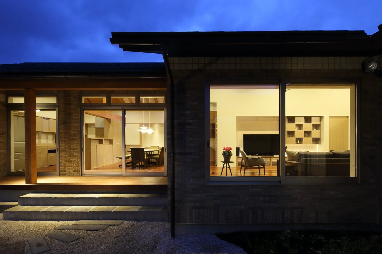 An evening view of the living and dining room from the main garden.