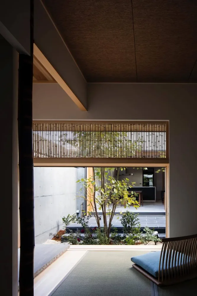 Bamboo quarter-sawn strips are used in the transom of the Japanese-style room, softly integrating the courtyard’s trees into the interior.