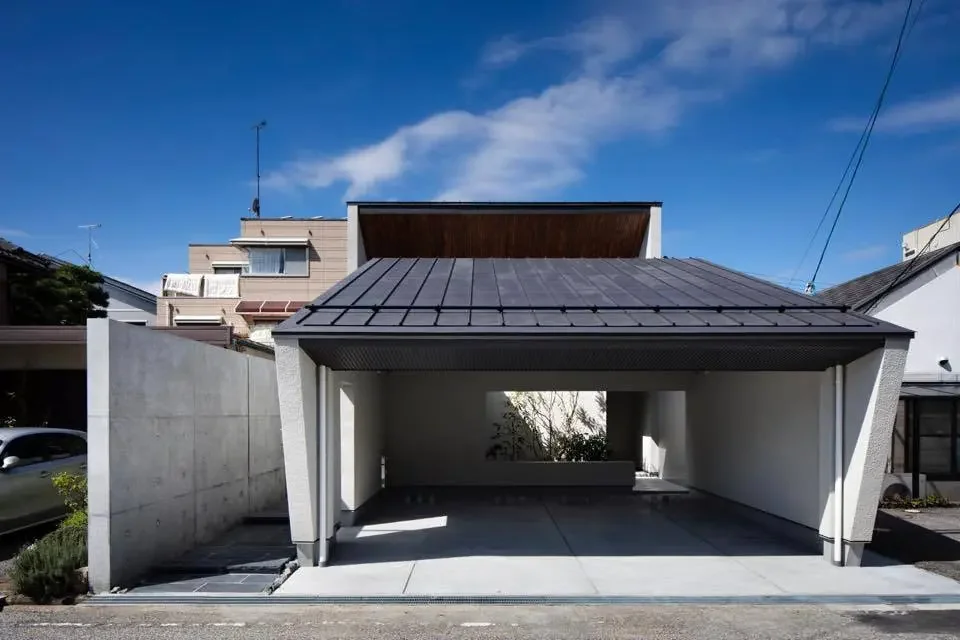 An open parking area accommodates two vehicles; the first courtyard is visible from the street.